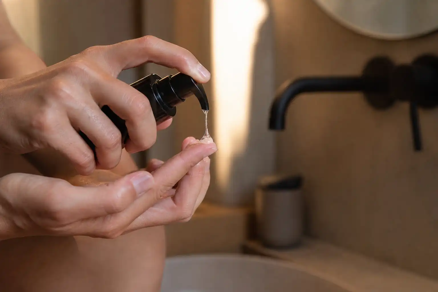 Des mains examinent un objet, autour de lubrifiant cbd amour, dans une salle de bain.